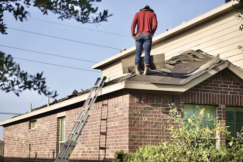 Professional roofer working on a residential roof in Welch Village
